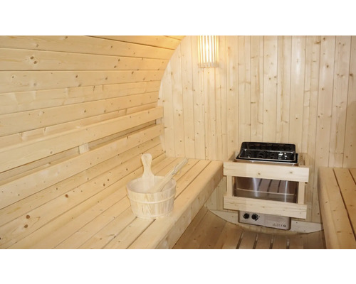 Innenansicht einer Holzfasssauna mit Bänken, Saunaofen und Saunazubehör