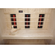 Innenansicht einer Sauna mit Infrarotstrahlern, Holzbänken und einem Holzeimer mit Schöpfkelle.