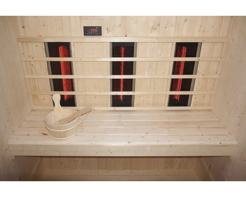 Innenansicht einer Sauna mit Infrarotstrahlern, Holzbänken und einem Holzeimer mit Schöpfkelle.