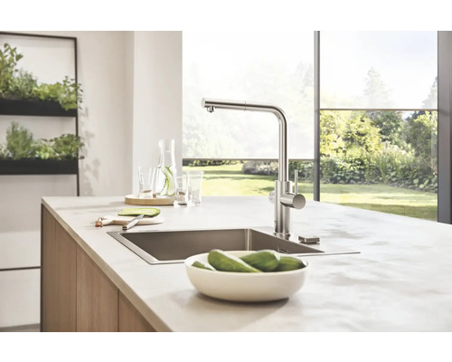 Küchenspüle mit Armatur und Lebensmitteln auf einer Küchentheke