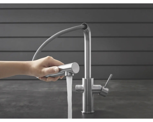 Küchenarmatur mit herausziehbarer Geschirrbrause und Wasserstrahl in der Hand