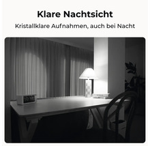 Nachtsichtaufnahme eines Zimmers mit Schreibtisch und Lampe