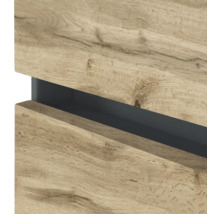 Detailansicht einer grifflosen Möbelfront in Eiche-Optik mit einer dunklen Griffmulde.