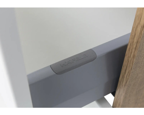 Nahaufnahme einer Schubladenzarge aus Metall mit Kunststoff-Abdeckkappe und Häfele Logo.