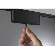 Hand befestigt Stromschiene an der Decke.