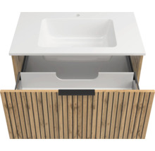 Waschtischunterschrank in Eiche Natur mit Lamellen-Design, weißes Waschbecken und eine offene Schublade mit schwarzer Griffleiste.
