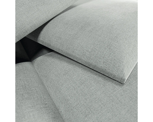 Nahaufnahme eines grauen Polsterstoffes mit gewebter Textur und überlappenden Stoffelementen.