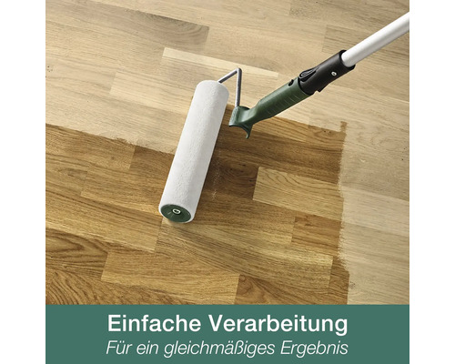 Farbroller beim Auftragen von Holzöl auf einen Parkettboden für eine gleichmäßige Oberflächenbehandlung.