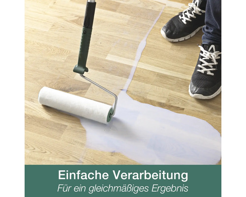 Auftragen einer Bodenversiegelung auf Holzboden mit einer Farbwalze für ein gleichmäßiges Ergebnis.