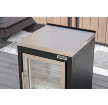 Tenneker Outdoor-Kühlschrank Modul mit Arbeitsplatte aus Edelstahl und Glastür in einer hellen Außenküche auf einer Terrasse.