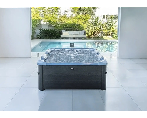 Moderner rechteckiger MSpa Whirlpool mit Sprudelfunktion und Nackenstützen in hellem Raum mit Pool- und Gartenblick.