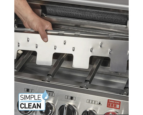 Eine Hand entnimmt eine Flammenabdeckung aus Edelstahl aus einem Gasgrill zur Reinigung, die Brennerrohre und das Simple Clean System sind sichtbar.