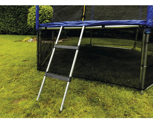Silberne Trampolinleiter aus Metall mit zwei schwarzen Kunststoffstufen an einem Trampolin im Garten.