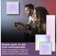 Zwei Personen beim Gaming in einem Raum mit verschiedenen quadratischen und rechteckigen LED-Wandpaneelen in unterschiedlichen Größen.
