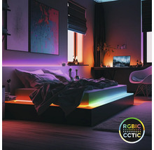 Modernes Schlafzimmer mit farbigen LED-Streifen unter dem Bettgestell und hinter dem Kopfteil. Smarte RGBIC- und CCT-Beleuchtung.