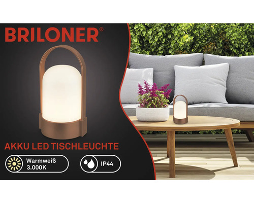 Briloner Logo, Akku LED Tischleuchte auf Holztisch in heller Gartenszene mit Sofa und Hecke, warmweiß 3000 Kelvin, spritzwassergeschützt IP44.