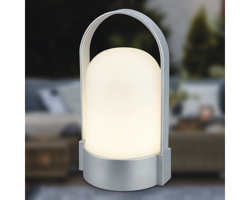 Tragbare LED-Tischleuchte mit silberfarbenem Fuß und Bügelgriff, kuppelförmiger Schirm, warmweißes Licht.