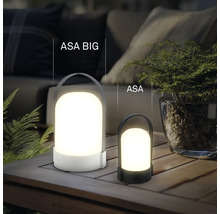 Zwei unterschiedlich große tragbare LED-Tischleuchten ASA BIG und ASA auf einem Holztisch im Außenbereich mit Pflanzen und Polstermöbeln.