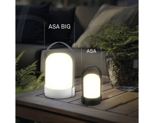 Zwei unterschiedlich große tragbare LED-Tischleuchten ASA BIG und ASA auf einem Holztisch im Außenbereich mit Pflanzen und Polstermöbeln.