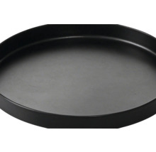 Runder schwarzer Untersetzer mit erhöhtem Rand.