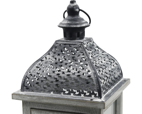 Nahaufnahme einer dekorativen Laterne mit Holzsockel und verziertem Metalldach mit Lochmuster sowie einem Ring zum Aufhängen.