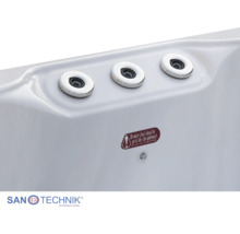 Detailansicht von drei Massagedüsen und einem Wasserstandssensor an der Innenwand einer Whirlpool-Badewanne. Sanotechnik Logo.