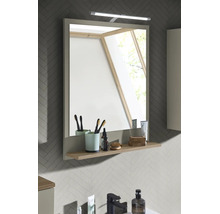 Moderner rechteckiger Badezimmerspiegel mit LED-Aufsatzleuchte und integrierter Ablage in Holzoptik vor einer grauen Wand mit Fischgrätenmuster.