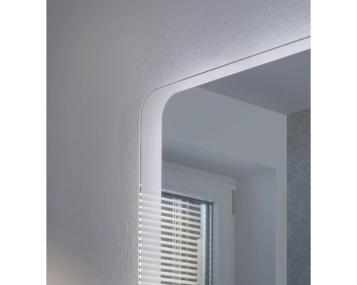 Detailaufnahme eines Badezimmerspiegels mit integrierter LED-Beleuchtung und abgerundeten Ecken.