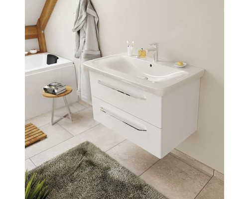Moderner wandhängender Waschtischunterschrank mit weißem Waschbecken und zwei Schubladen mit Chromgriffen in einem hellen Badezimmer.
