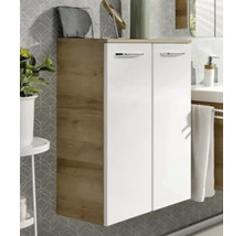 Moderner Badezimmer-Seitenschrank mit zwei weißen Türen, Holzkorpus in Eichenoptik und silbernen Griffen vor einer gemusterten Wand.