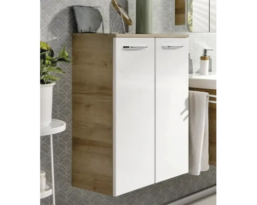 Moderner Badezimmer-Seitenschrank mit zwei weißen Türen, Holzkorpus in Eichenoptik und silbernen Griffen vor einer gemusterten Wand.