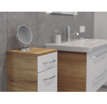 Moderner Badezimmer-Beistellschrank mit zwei weißen Schubladen und Korpus in Holzoptik neben einem Waschtisch mit Kosmetikspiegel.