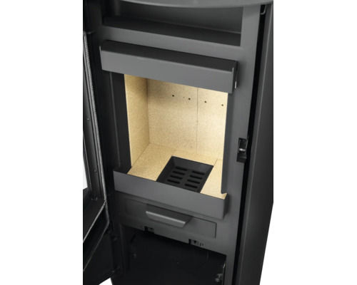 Nahaufnahme der Brennkammer eines Kaminofens mit Vermiculite-Auskleidung und gusseisernem Rost.