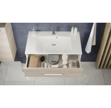 Moderner Waschbeckenunterschrank mit weißem Waschbecken und geöffneter Schublade in Holzoptik mit Badutensilien.