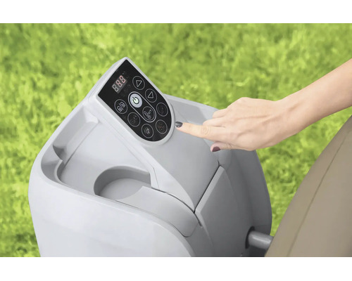 Hand bedient das digitale Bedienfeld einer Whirlpool-Pumpe im Außenbereich auf einer Rasenfläche.
