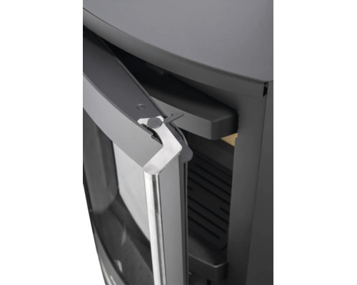 Detailansicht eines Kaminofens mit leicht geöffneter Tür, silberfarbenem Metallgriff und Türdichtung.