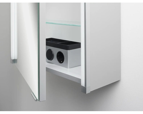 Spiegelschrank für das Badezimmer mit geöffneter Tür, einem Glasfachboden und einer integrierten Doppelsteckdose im Innenraum.