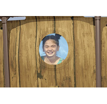 Kind blickt durch ein rundes Sichtfenster eines Aufstellpools mit Paneelen in Holzoptik.