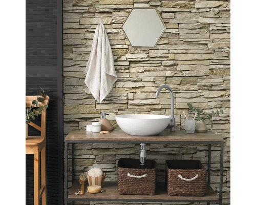 Modernes Badezimmer mit strukturierten Verblendsteinen an der Wand, Aufsatzwaschbecken auf einem Holzregal und sechseckigem Spiegel.