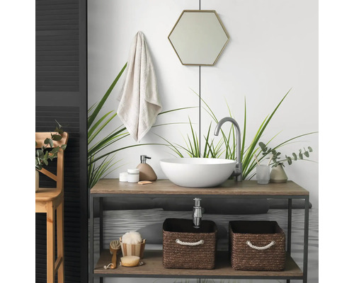 Modernes Badezimmer mit rundem Aufsatzwaschbecken auf einem Holzwaschtisch, hoher Armatur, hexagonalem Spiegel und geflochtenen Aufbewahrungskörben.