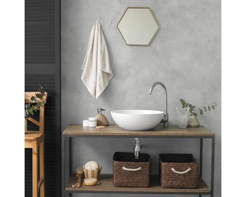 Modernes Badezimmer mit weißem Aufsatzwaschbecken auf einer Holzkonsole. Inklusive hohem Wasserhahn, sechseckigem Spiegel und Flechtkörben.