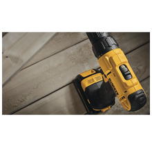 DeWALT Akku-Bohrschrauber auf einer Holzoberfläche mit Fokus auf den Gangwahlschalter und das DeWALT Logo.