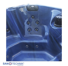 Innenansicht eines blauen Whirlpools mit Massagedüsen und einer schwarzen Nackenstütze.