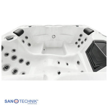 Innenansicht eines weißen Whirlpools mit zahlreichen Düsen, schwarzen Kopfstützen und Sanotechnik Logo.