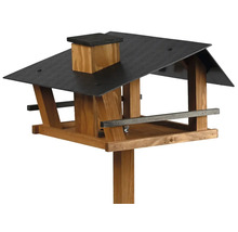 Vogelfutterhaus aus Holz mit dunklem Dach, Schornstein und Ständer für Wildvögel.