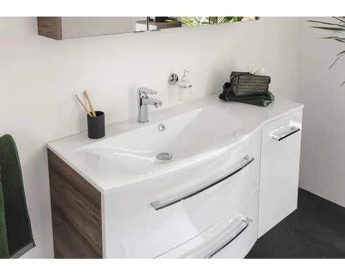 Moderner Badezimmer-Waschtisch mit glänzender weißer Front, Seitenteil in Holzoptik, integriertem Waschbecken und verchromten Griffen.