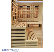 Innenansicht einer Infrarotkabine aus hellem Holz mit Eckbänken und Infrarotstrahlern hinter Holzgittern. Santechnik International Logo.