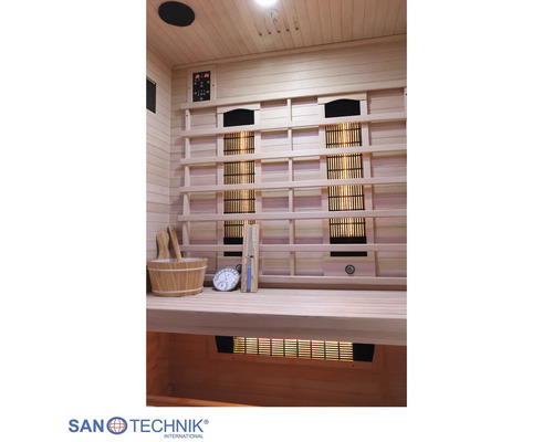 Innenansicht einer Infrarotkabine aus Holz mit Infrarotstrahlern, Steuerung, Saunakübel, Kelle, Sanduhr und Thermometer.