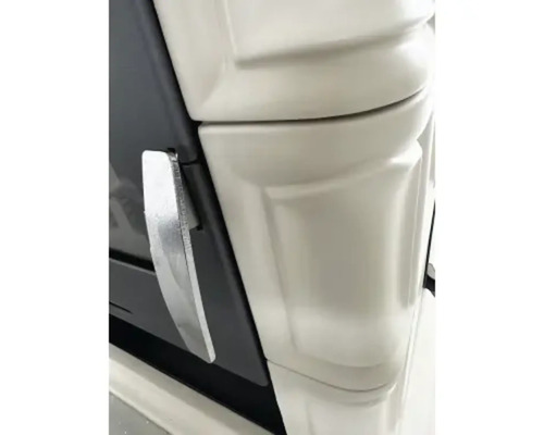 Detailansicht eines Kaminofens mit Metallgriff und Keramikverkleidung