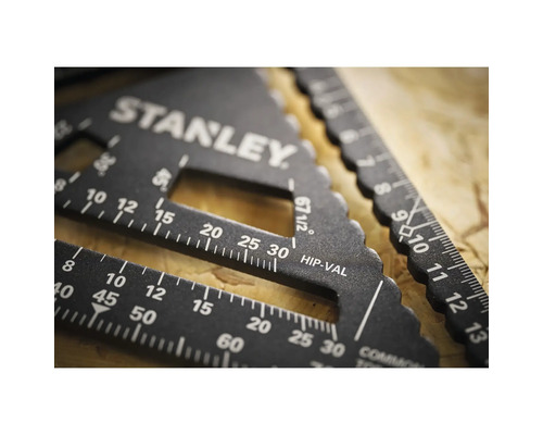 Schwarzer Stanley Sparrenwinkel aus Metall mit Skalen für Winkel in Grad und Dachsparren auf einer Holzoberfläche.